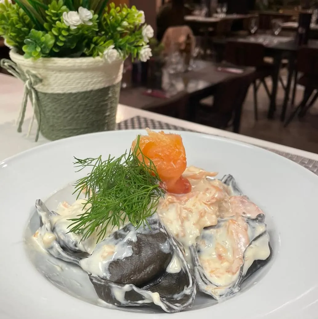 Raviolis negros con salsa de salmón y eneldo, con la sala al fondo