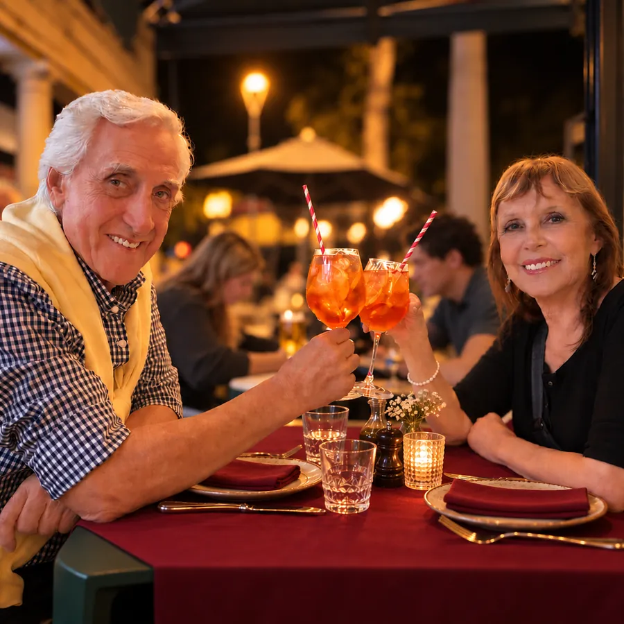 A couple toasting with spritz at a terrace table at night